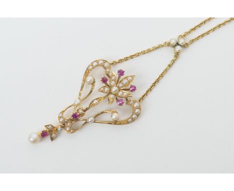 Late Victorian ruby and pearl openwork pendant necklace, in 15ct gold, the Art Nouveau inspired pendant centred with a flower