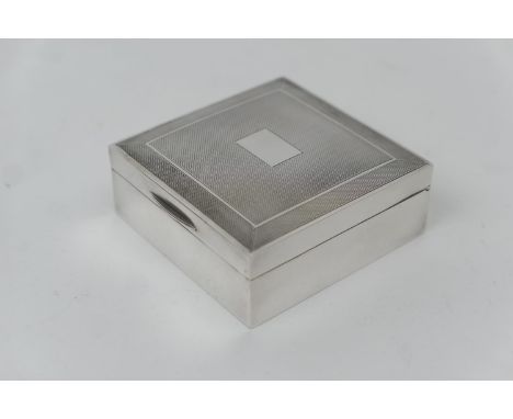 Modern silver cigarette box, Birmingham 1965, square form with engine turned decoration around a vacant cartouche, cedar line