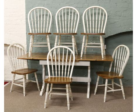 An oak and cream painted drawleaf refectory dining table and six hoop back dining chairs raised on bobbin turned supports.