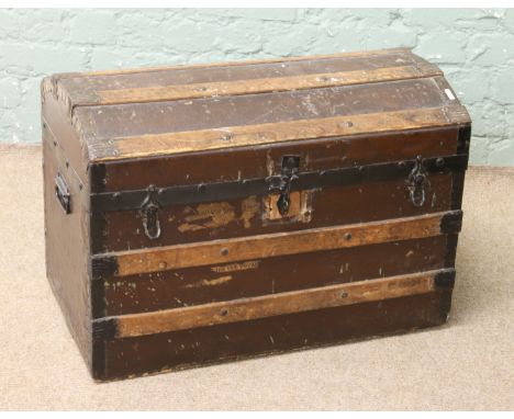 A vintage wooden bound dome top travelling trunk.
