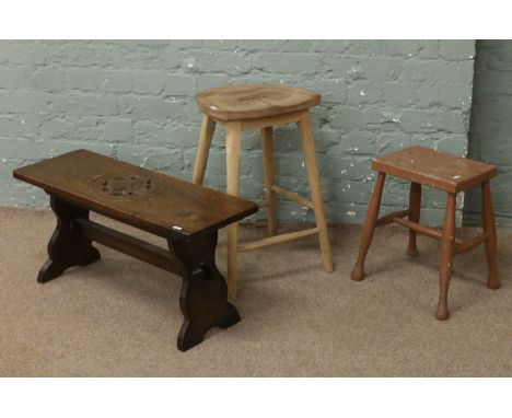An ash kitchen stool, a painted stool and a carved oak bench with Yorkshire rose motif.