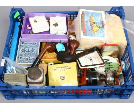 A box of collectables including vintage playing cards, pipes, storage tins, costume jewellery etc.