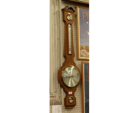 A mahogany banjo barometer with silvered dials.