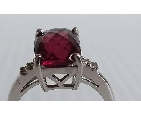 A 9ct white gold ruby-colour ring with diamond decoration to shoulders in a claw setting, hallmarked, size N, 4.2g 