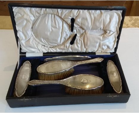 A George V five-piece cased silver brush set (no hand mirror) with engine turned design, Birmingham, 1917 