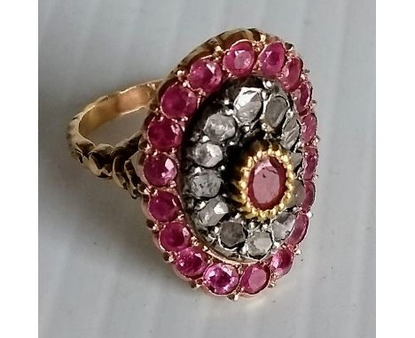 A 19th century oval ruby and diamond cluster ring on a yellow gold setting comprising eighteen old rose-cut rubies surroundin