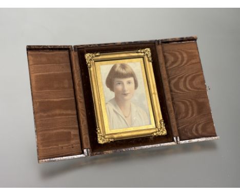 A 1920s over-painted photographic portrait in original gilt composition frame and folding brown velvet lined case with easel 