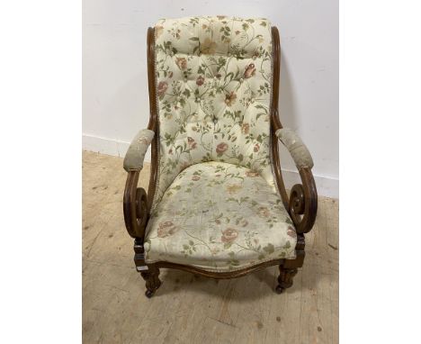 William IV oak armchair, of scroll form with a button back and part padded arms above a stuffover seat, standing on turned an