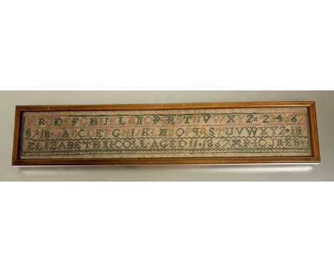 A Victorian sewn work sampler by Elizabeth Nicoll aged 11 1867 with traditional cross stitch alphabet and numbers in a glazed