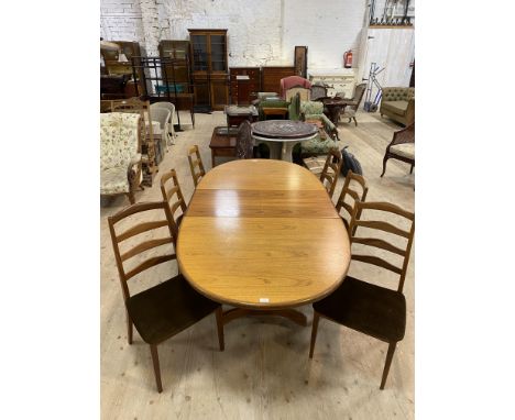 G Plan teak dining table, with an oval pull apart top and fold out leaf, standing on shaped supports united by a stretcher, 7