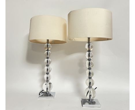 A pair of Heathfield &amp; Co table lamps each with a column of glass balls raised on square chrome bases with cream satin sh