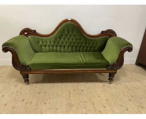 Victorian mahogany arch back sofa, with a shaped button back above ascoll arms and a loose fitted seat cushion, all covered i