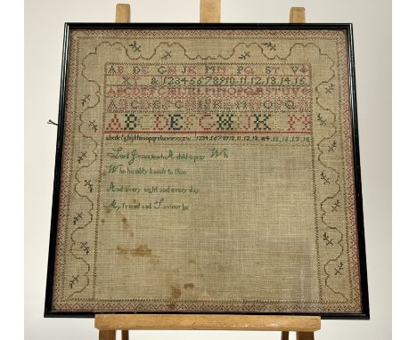 A framed 19thc cross stitch sewn work sampler, with six rows of stylised alphabet and numerical design with prayer enclosed w