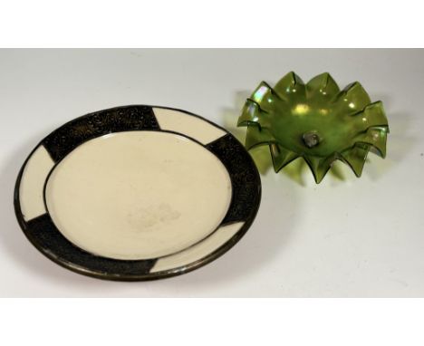 A large fruit bowl, with cream glazed and etched cast metal edge (w-41.5cm h-9.5cm) togther with a iridescent green glass ruf