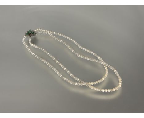 A 14ct white gold clasp mounted double cultured pearl choker style necklace, the clasp set six round faceted emeralds: l. x 1