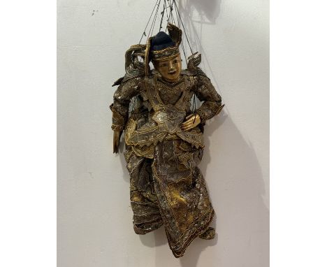 A Sri Lankan highly decorated carved gilt wood articulated puppet with hand-made beaded, silk work costume, with gilt painted