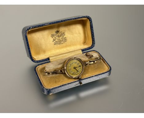 A vintage 9ct gold cased ladys wrist watch on expanding gold plated bracelet with gilt dial and Arabic numerals: d. x 2.cm wi