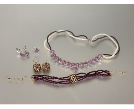 An Indian silver boteh and ruby stone mounted suite of jewellery to include: a ring Q, a pair of pendant drop earrings: l. x 