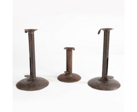 the pair with handle to the sconce and central sliding mechanism above domed bases, 22cm high, the single candlestick of iden
