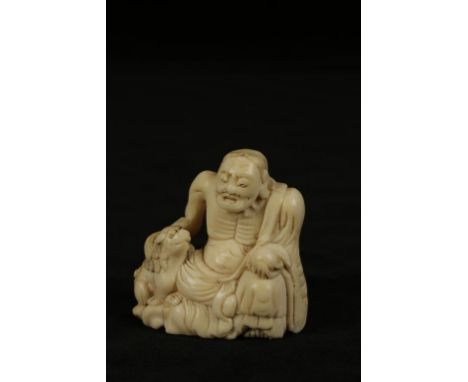 A JAPANESE IVORY NETSUKE of an immortal with a Shi-Shi, 4.5cm high