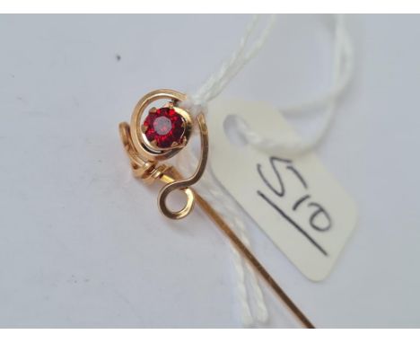 A gold stick pin with single garnet