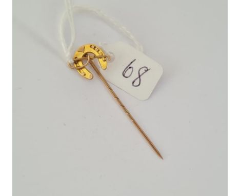 An antique hunting stick pin designed as horse shoe with riding crop in gold 