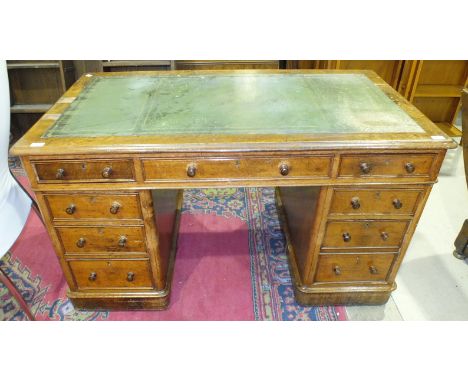 An Edwardian oak knee-hole desk, the rectangular top fitted with three frieze drawers above five pedestal drawers, 136.5 x 75
