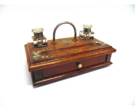 AN EDWARDIAN OAK DESK STAND  fitted with two glass inkwells, 28cm wide; together with a set of oak and brass postage scales