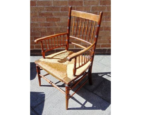 A PROVINCIAL RUSH SEAT ARMCHAIR the backrest and arms with spindle supports. 86cm high, 51cm wide, 52cm deep 