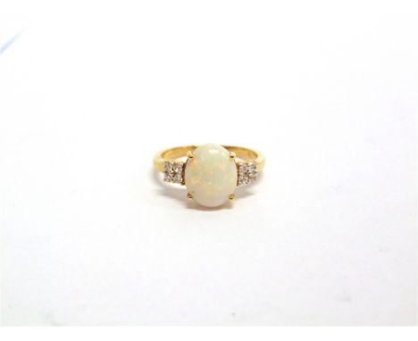 AN OPAL 9 CARAT GOLD RING with a trio of stones to each shoulder, finger size Q, 2.7g gross