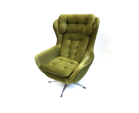 A 1970S SWIVEL ARMCHAIR  with green button upholstery on chrome five prong base