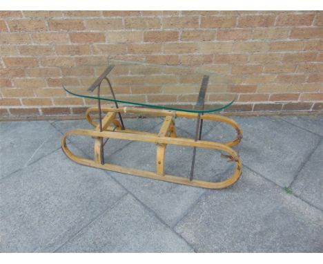 A VINTAGE WOODEN SLED  with metal runners, adapted as a coffee table