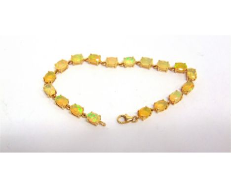 A 9 CARAT GOLD OPAL BRACELET composed of eighteen shallow oval cabochons, 18.5cm long, 7g gross