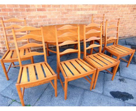 A LIGHT ELM ERCOL 'SAVILLE' EXTENDING OVAL DINING TABLE  and matching set of six ladderback chairs