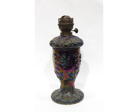Purple carnival glass oil lamp, the body decorated with roses and butterflies in deep iridescent colours, with removable rese