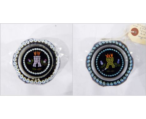 Two glass paperweights by Caithness, depicting a flaming castle flanked by thistles in millefiori canes on a black ground, on