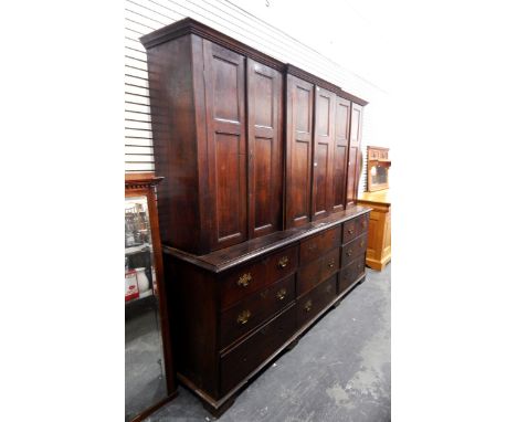 Large 19th century oak breakfront housekeeper's cupboard with three panelled cupboards enclosing shelves, with nine drawers b