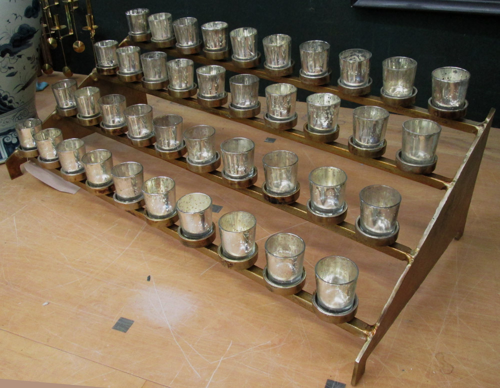 CHURCH VOTIVE CANDLE HOLDERS, forty candles on stepped metal base, 90cm L.