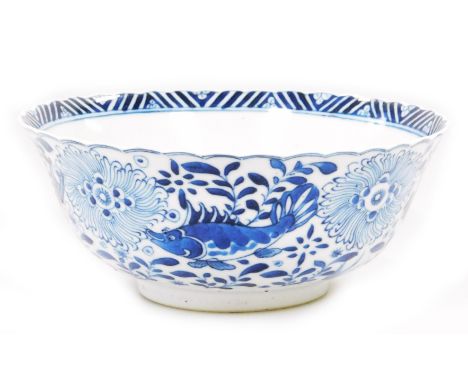 A Chinese porcelain blue and white bowl, four character stylised Kangxi mark beneath, of shaped circular outline, profusely d