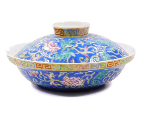 A Chinese porcelain bowl and cover, profusely decorated with flowers, predominately in pink, green and yellow, on a blue grou