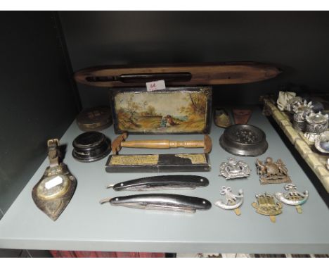 A selection of vintage and antique curios and trinkets including military cap badges