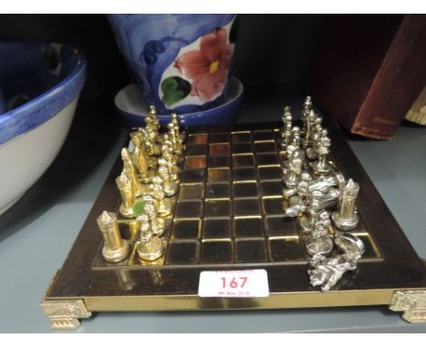 A vintage miniature chess set with metal cast figures in a Tudric style