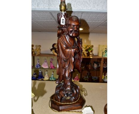 A LARGE WOODEN FIGURAL TABLE LAMP, a hand carved figure of Chinese Shou Lao (god of Longevity), lotus flower on his back hold