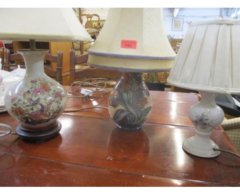 A contemporary Moorcroft floral patterned table lamp with shade and two other table lamps and a gilt framed wall mirror 
