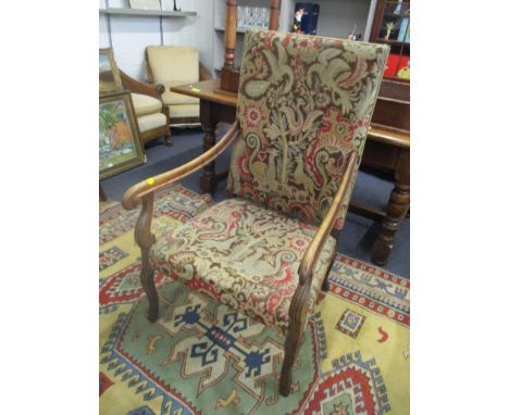 An early 20th century walnut framed and tapestry upholstered armchair having scrolled arms on carved cabriole legs 