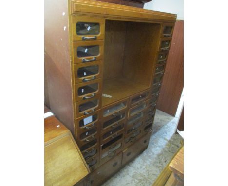 A mid 20th century vintage large haberdashery cabinet with a central open shelf, twenty small glaze fronted drawers, ten larg