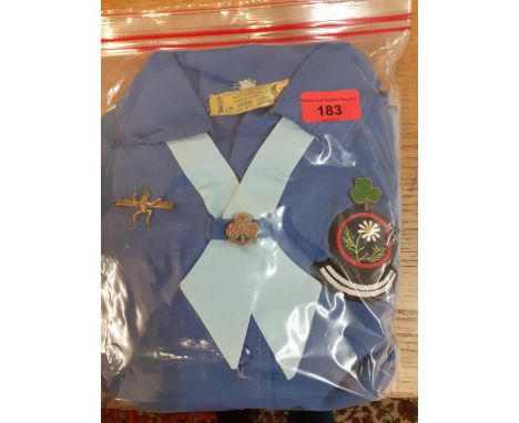 A vintage Girl Guides uniform in blue with cloth and metal badges and Girl Guide manual Location: RWB 