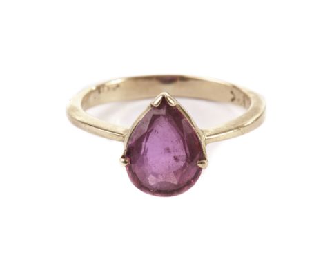 A ruby solitaire dress ring, the teardrop shaped red stone in a yellow metal mount marked 18k 