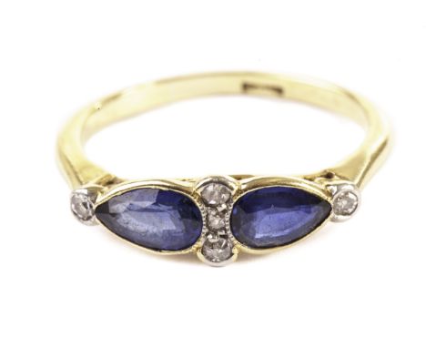 A pretty Edwardian period sapphire and diamond dress ring, having a pair of teardrop shaped good blue coloured stones and sev