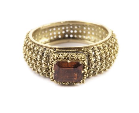 An antique gold and hessonite dress ring, the rectangular orange coloured stone in an ornate setting, the thick band with app